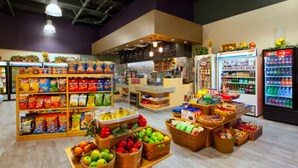 A grocery store with shelves stocked with snacks, fresh produce, and beverages.