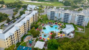 Un complex hoteler amb diversos edificis, una piscina central i vegetació circumdant.
