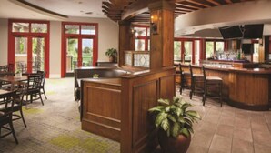 A restaurant with a bar area, wooden furniture, and large windows. - Marriott's Shadow Ridge II (1 Bedroom) (Palm Desert)