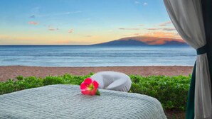 Vista de la playa con una cama y una flor sobre ella.