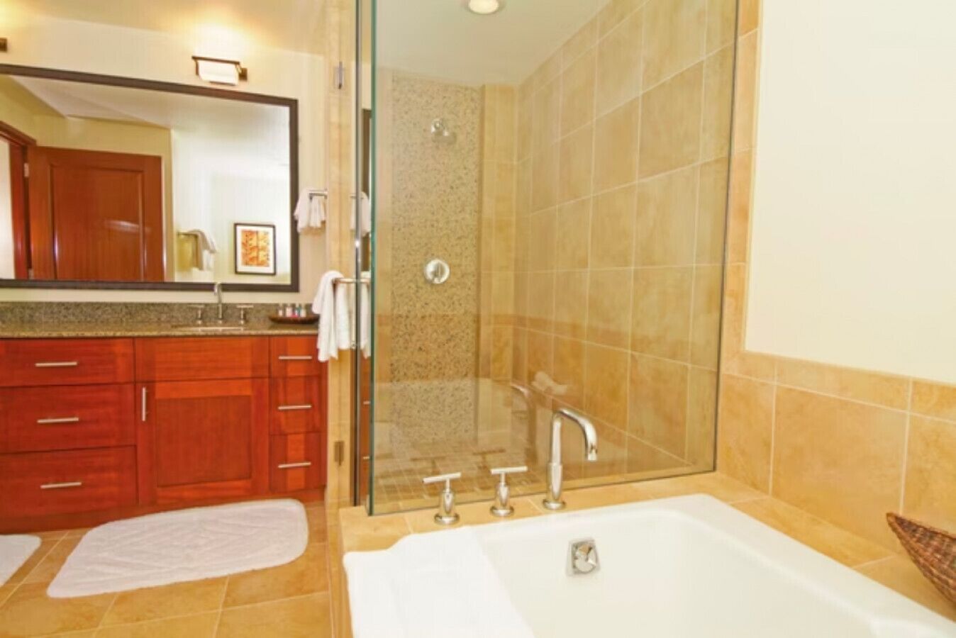 A modern bathroom with a glass-enclosed shower, a large bathtub, and wooden cabinetry.