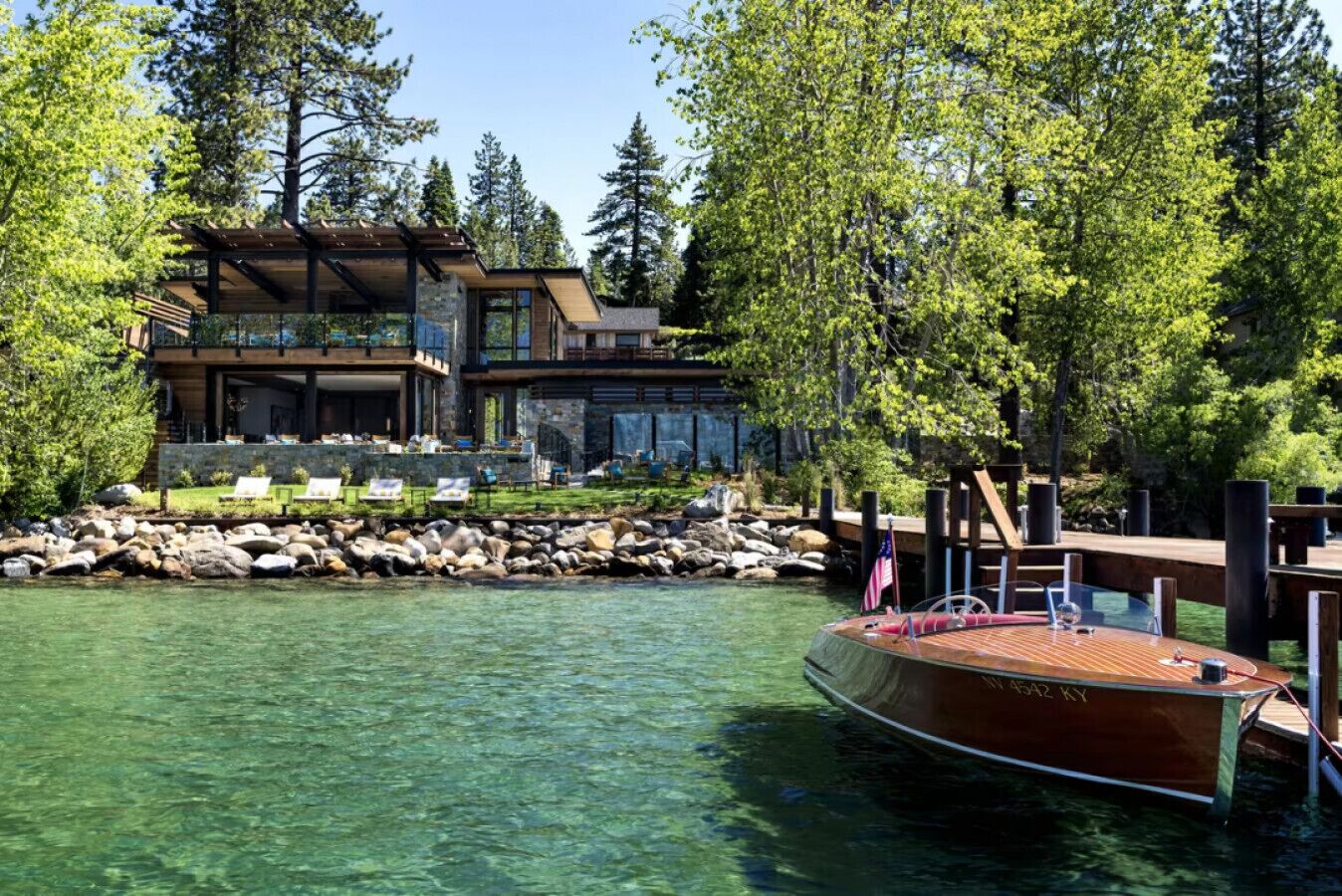 A modern house with a dock and a boat.