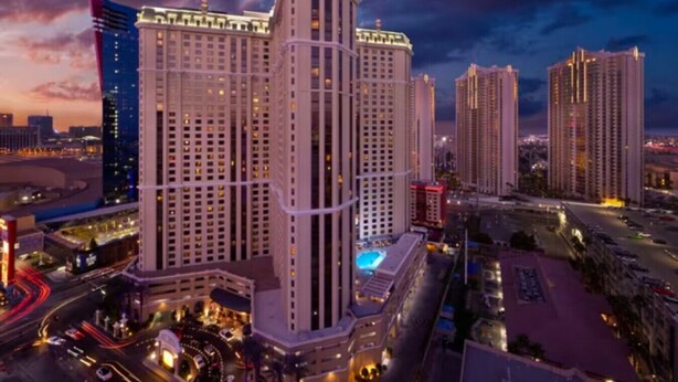A high-rise hotel with multiple floors, a pool on the rooftop, and a view of the surrounding cityscape at dusk. - Marriott's Grand Chateau (Studio) (Las Vegas)