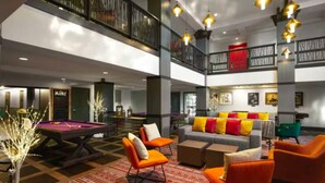 A spacious lobby with a pool table, orange chairs, a grey sofa with colorful cushions, and a red and white patterned carpet. - Marriott's MountainSide (1BR) (Park City)
