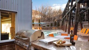An outdoor patio with a grill, pool, and seating area. - Marriott's Summit Watch (1BR) (Park City)