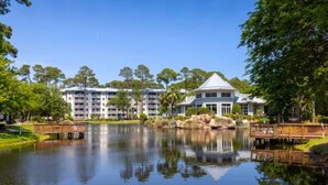 A hotel with a large pond, a wooden bridge, and a white building with a green roof. - Marriott's SurfWatch (2BR) (Hilton Head Island)