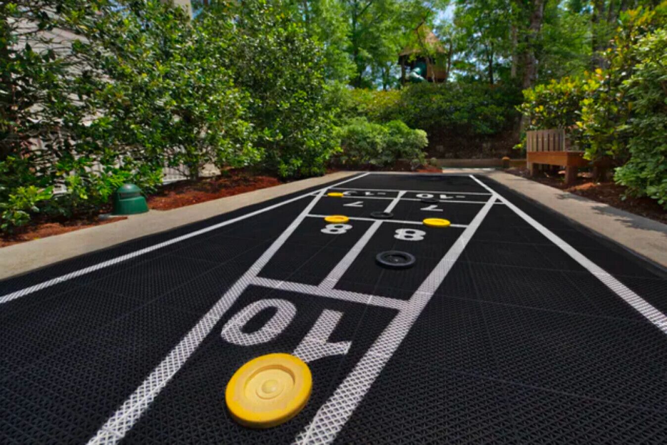 A shuffleboard table with numbered scoring areas and pucks.