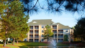 A multi-story hotel with a central courtyard, a fountain, and surrounding trees. - Sheraton Broadway Resort (1BR) (Myrtle Beach)