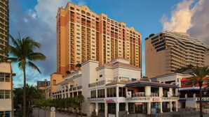 Un hotel con varios pisos, un patio central y una variedad de tiendas en la planta baja.