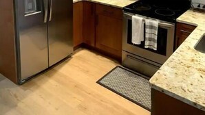 Una cucina con mobili in legno, elettrodomestici in acciaio inossidabile e un piano di lavoro in granito.