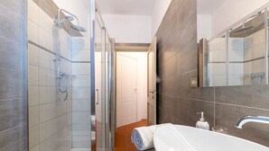 A modern bathroom with a glass-enclosed shower, a white sink, and a large mirror. - Apartment located on the first mezzanine floor of a building without a lift.Immersed in the countryside, it is 15 minutes away from the center of Parma, by car.In 45 m2 of space it comfortably accommodates 4 guests with a double bedroom and a queen-size  (Parma)