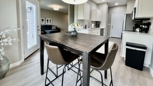 A modern kitchen with a central island, two bar stools, and a pendant light. - New Construction Townhome - 3 King Beds/2.5 Bathroom! (Cedar Falls)
