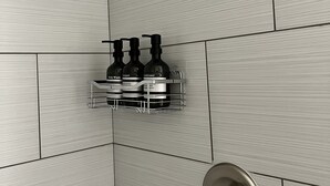 Un espace douche équipé d’un robinet mural et d’un pommeau de douche.