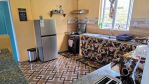 A compact kitchen with a refrigerator, stove, and sink.