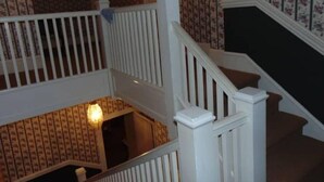 Un escalier avec des rampes blanches et un papier peint à motifs en arrière-plan.