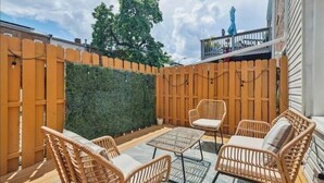 A patio with wicker furniture, a table, and a green hedge. - Entire Rowhome in Northwest Washington (Dedicated Parking Spot Available) (Washington)