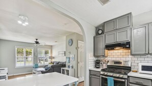 A modern kitchen with grey cabinets, a white countertop, and stainless steel appliances. - Bonita Beach House by Ryson Vacation Rentals (Galveston)