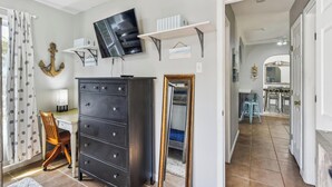 A bedroom with a large wardrobe, a flat-screen TV, a desk, and a chair. - Bonita Beach House by Ryson Vacation Rentals (Galveston)