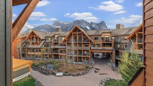 A lodge with multiple wooden buildings, a central courtyard, and a mountain backdrop.