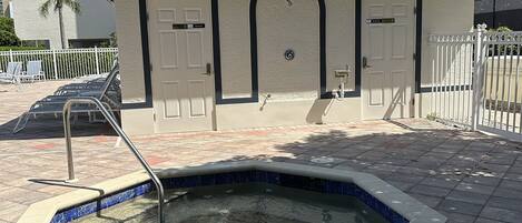 A small building with a pool, two doors, and a metal roof.