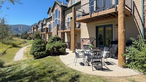 A residential building with multiple balconies, a patio area with outdoor furniture, and a view of a mountain range. - Mountain Escape in Eden, Utah (Eden)