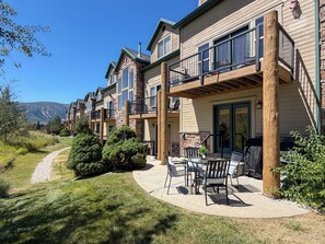 A residential building with multiple balconies, a patio area with outdoor furniture, and a view of a mountain range. - Mountain Escape in Eden, Utah (Eden)