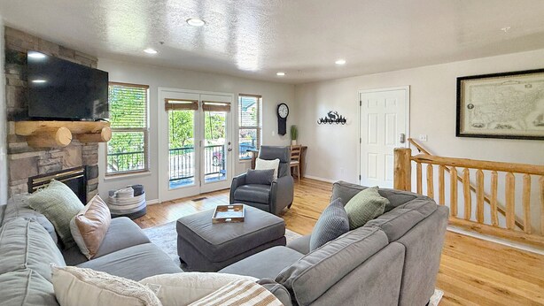 A living room with a fireplace, a television, a sofa, and a dining area. - Mountain Escape in Eden, Utah (Eden)