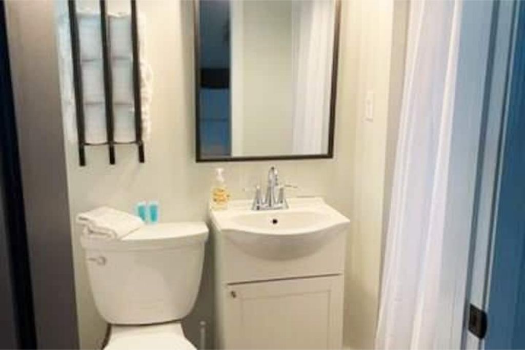 A bathroom with a toilet, a sink, and a mirror.