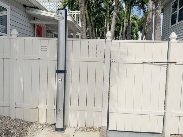 A gated area with a metal post and a white picket fence.
