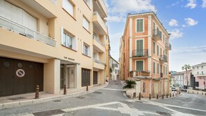 Vista de la calle con un edificio identificado como "LOU NIEDJOU" y un letrero que indica "NO ESTACIONAR".