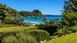 A coastal landscape with a clear view of the sea, boats, and a beach.