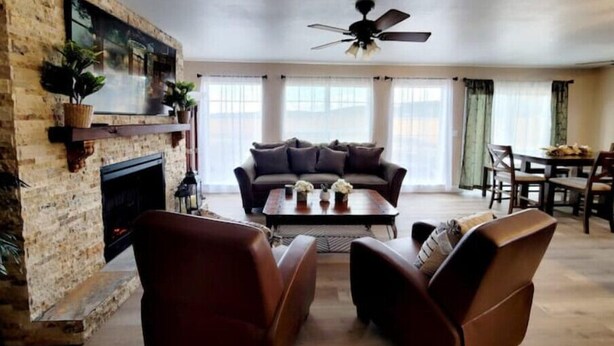 A spacious living room with a fireplace, a sofa, and a coffee table. - Bryce Canyon Cottage! Just a few of mins away. (Panguitch)