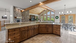 A spacious kitchen with a large island, wooden cabinets, and a stone backsplash. - New to Market Private Weber River Access Stunning Family Retreat (Morgan)