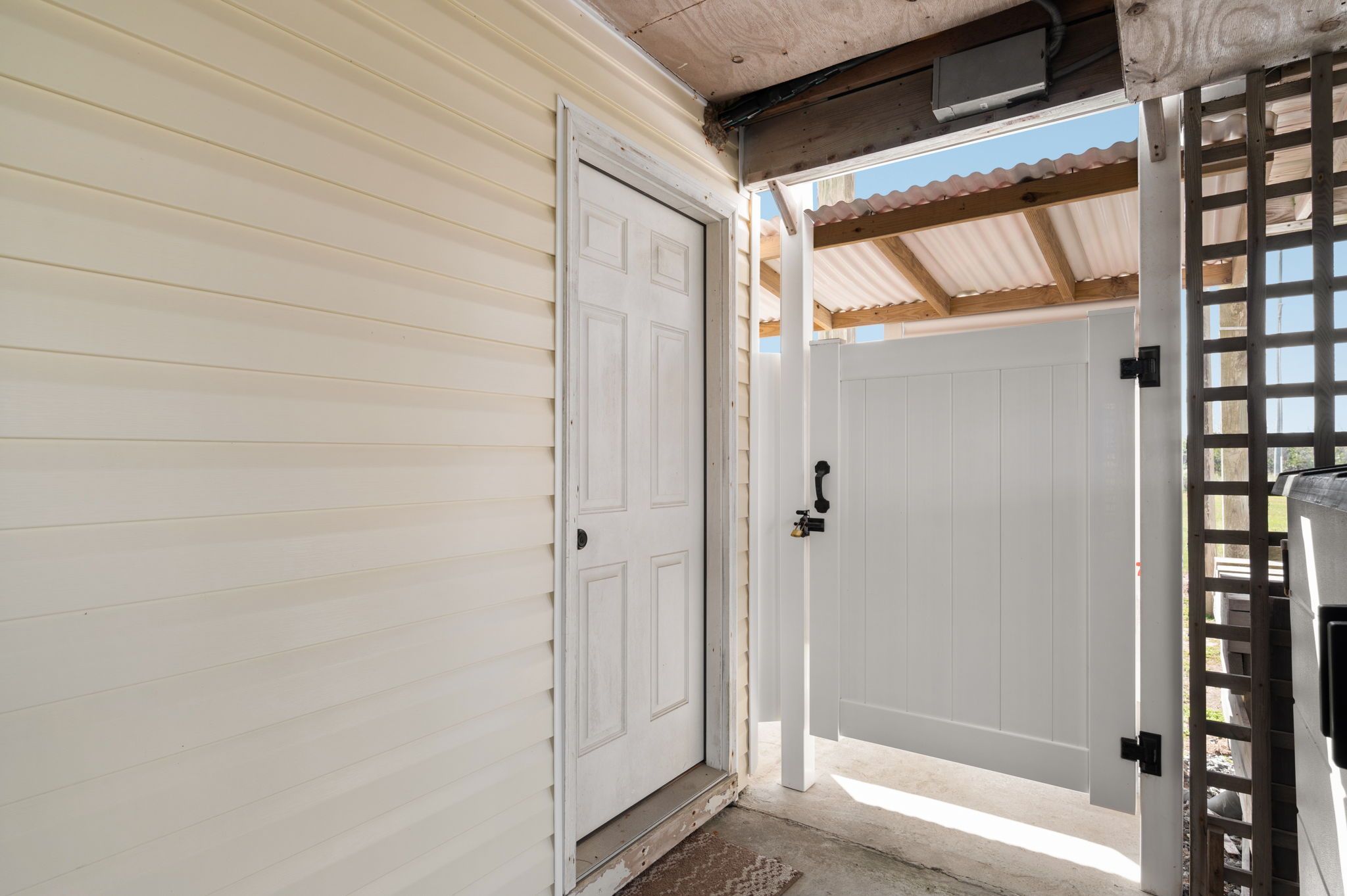 A garage door with a metal gate, a wooden door, and a metal garage door opener.