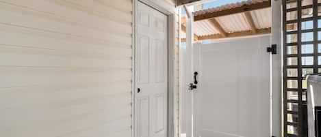 Une porte de garage avec un portail métallique, une porte en bois et un ouvre-porte de garage métallique.