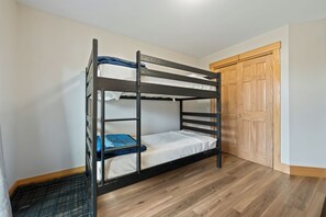 A bunk bed with a metal ladder, a wooden door, and a wooden floor. - Saddleback - Black Gnat Condo #12 (Sandy River Plantation)