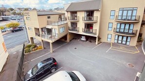 Een hotel met meerdere verdiepingen, balkons, een parkeerplaats en een helder uitzicht op de omgeving.