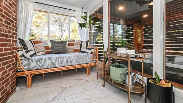 A cozy room with a rattan sofa, a green plant shelf, and a view of the outdoors. - Luxe | Hot Tub | Firepit | Heat Floors | EV | Walk2Matthews (Matthews)