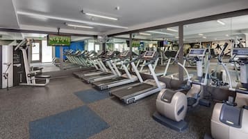 A gym with multiple treadmills, exercise bikes, and weight machines.