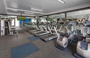 A gym with multiple treadmills, exercise bikes, and weight machines.