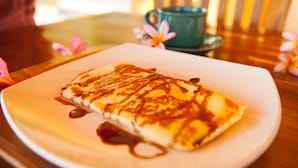 A plate with a crepe on a wooden table. - Dayuh House (Penida Island)
