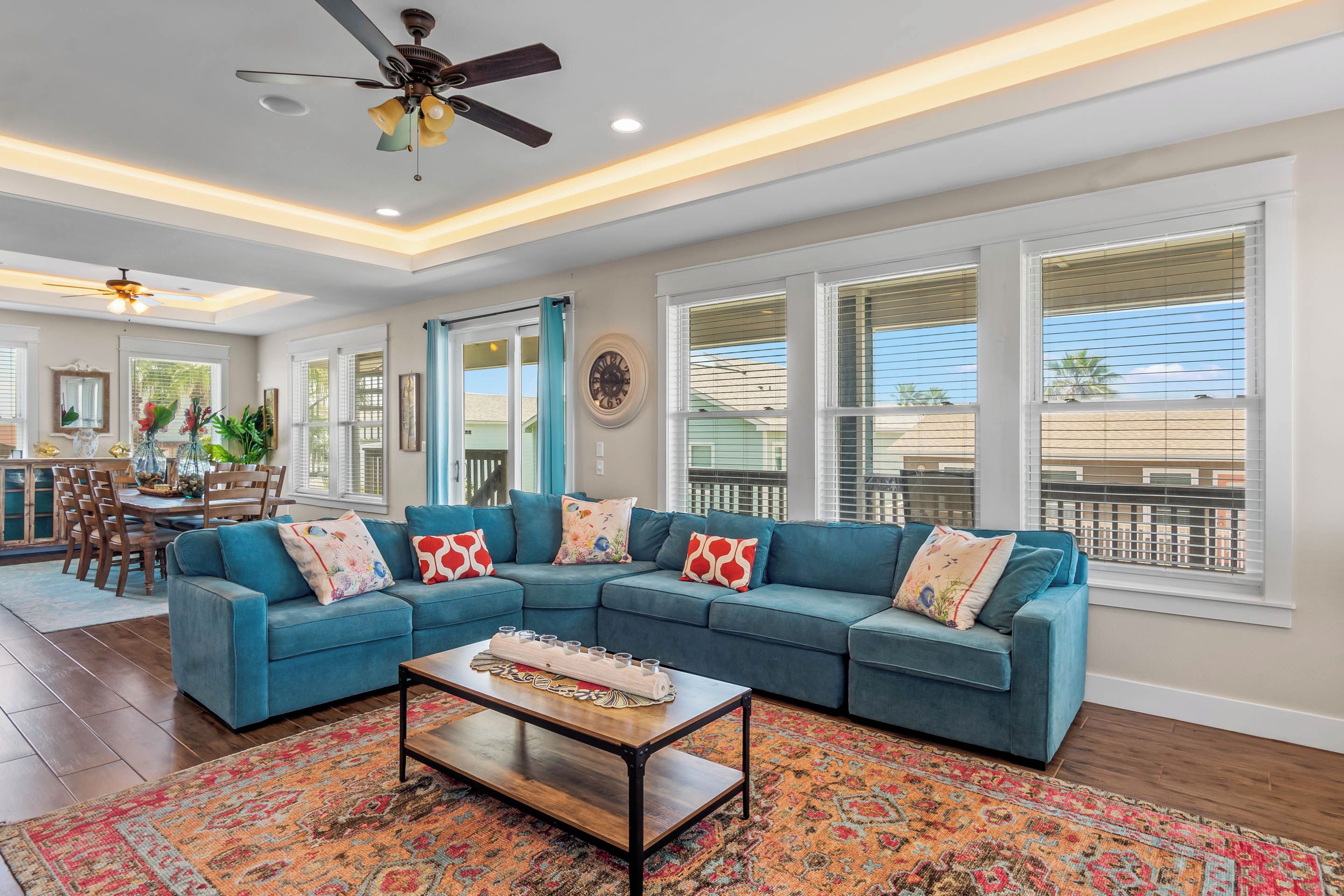 A spacious living room with a sectional sofa, a coffee table, and a patterned rug.