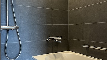 Un baño moderno con bañera, ducha y accesorios cromados.