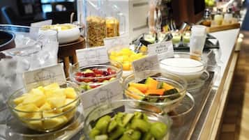 A buffet with various fruit bowls and a coffee machine.