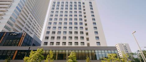Un moderno edificio de hotel con fachada de vidrio y varios pisos.