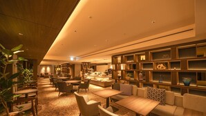 Un área de lounge moderna con asientos, una barra y estantes decorativos.