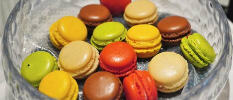 Un cuenco de vidrio transparente con macarons de varios colores.