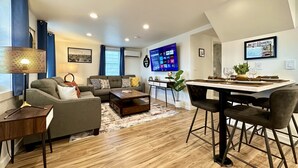 Un salon moderne avec un canapé, une table basse et un coin repas.