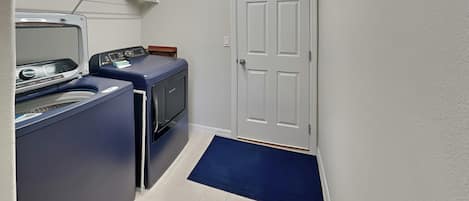 A laundry room with a washing machine, dryer, and a door.