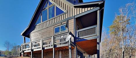 A modern two-story house with a large balcony and a covered porch area.
